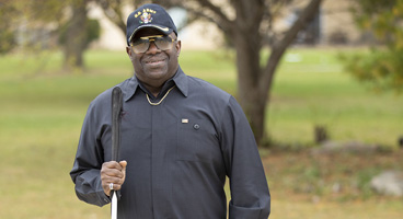 Lee, a blind Army veteran, smiles with his cane.
